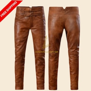May include: Brown leather trousers with a distressed finish. The trousers feature a double-buckle closure at the waist and a fitted design. The image shows the front and back of the trousers. The text "LONDON LUX LEATHER" is visible.