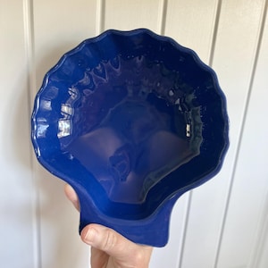 May include: A set of three ceramic mugs with a speckled, matte finish. The mugs are in shades of cream, light gray, and dark gray. Each mug has a simple, minimalist design, perfect for coffee or tea.