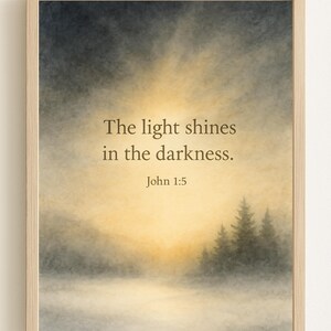 May include: Framed art print featuring a serene landscape with a sunrise and silhouetted trees. The text "The light shines in the darkness. John 1:5" is displayed in the center, set against a soft, watercolor-like background.