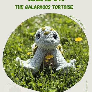 May include: A handmade crochet turtle named "Islador" with the text "The Galapagos Tortoise". The turtle is light blue with green and yellow accents, sitting in green grass with a yellow flower. The image has the text "Thrive.well.handmade".