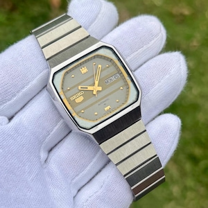 May include: A handmade wooden sign with the text "Welcome to our home" in a handwritten style. The sign is painted white with a distressed finish and features a black border. A small, decorative heart is attached to the bottom.