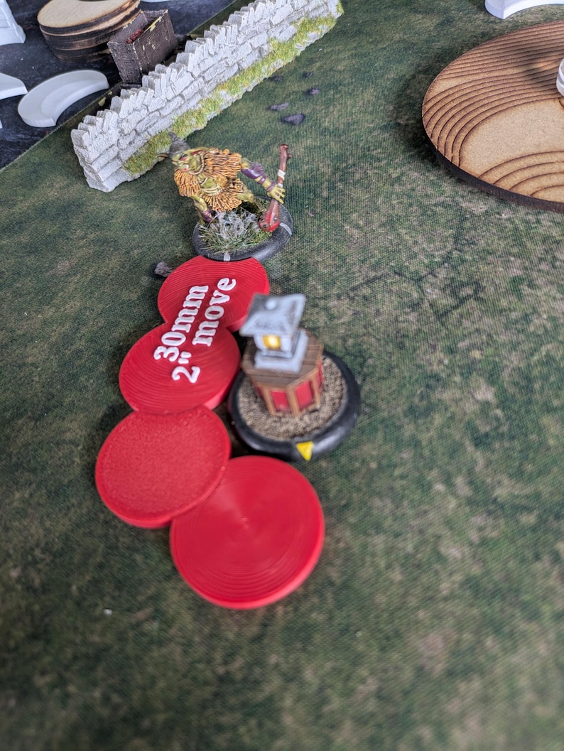 K&ouml;nnte beinhalten: Eine Tabletop-Spielszene mit einer Miniaturfigur, einer Laterne und roten kreisf&ouml;rmigen Markierungen. Die Markierungen sind mit "30mm 2" move" beschriftet. Die Szene spielt auf einer gr&uuml;nen, strukturierten Oberfl&auml;che. Die Figur hat einen Speer.