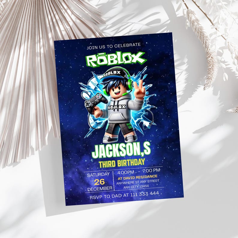 May include: A rectangular birthday invitation card featuring a Roblox theme with a dark blue starry background. A cartoon character wearing a grey hoodie and cap holds a game controller. Text includes JOIN US TO CELEBRATE, ROBLOX, JACKSON,S THIRD BIRTHDAY, and event details.