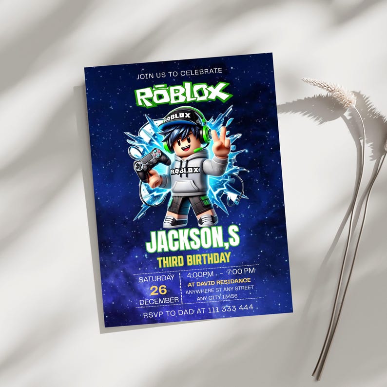 May include: A rectangular birthday invitation card featuring a dark blue space background with the Roblox logo at the top. A cartoon character wearing a grey hoodie and green headphones holds a game controller. Text includes JACKSON,S THIRD BIRTHDAY.