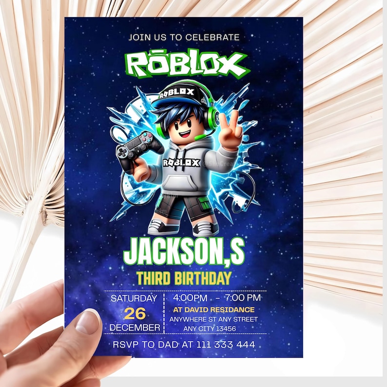 May include: A rectangular birthday invitation card featuring a Roblox theme with a dark blue starry background. A cartoon character wearing a grey hoodie and green headphones holds a game controller. Text includes JOIN US TO CELEBRATE, ROBLOX, JACKSON,S THIRD BIRTHDAY, and event details.