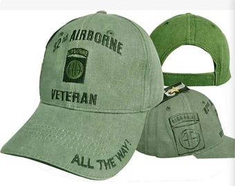 May include: Green baseball cap with the text "32nd AIRBORNE VETERAN" and "ALL THE WAY!" The cap features a patch with the Airborne insignia. The cap is made of a durable fabric and has a curved brim.