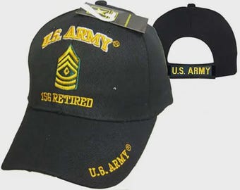 May include: Black baseball cap with "U.S. ARMY" embroidered in gold. The cap features a gold and green insignia and the text "1SG RETIRED". The back of the cap also has "U.S. ARMY" embroidered in gold.