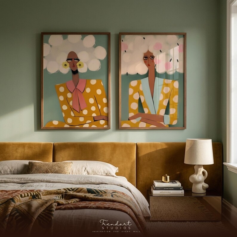 Whimsical wall art bedroom — expressive women diptych above deep mustard velvet headboard, sage green walls, boho eclectic decor with ceramic lamp and nightstand