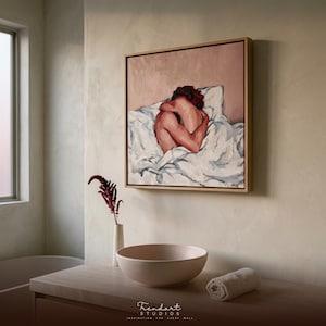 wabi sabi wall art in a neutral plaster room. A light oak floating frame surrounds a soft terracotta figure painting above a wood console with a rounded stone vessel bowl and a single dried branch.