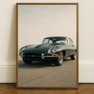 Puede incluir: Impresión enmarcada de un coche deportivo clásico verde oscuro. El coche tiene un diseño elegante con detalles cromados y ruedas de radios. La imagen está ambientada sobre un fondo neutro, enfatizando las elegantes líneas del coche.