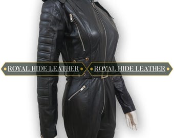 Puede incluir: Mono de cuero negro con cuello alto, múltiples cremalleras y cinturón. Las mangas tienen detalles acolchados en la parte superior de los brazos. El texto "ROYAL HIDE LEATHER" está impreso.