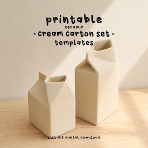 Puede incluir: Dos recipientes de cerámica de color crema con forma de cartón de leche de diferentes alturas. El texto "printable ceramic cream carton set templates" y "instant digital download" aparece en letras negras sobre y debajo de los objetos.
