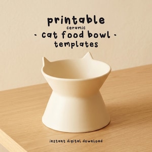 Puede incluir: Un cuenco de cerámica color crema para comida de gato con detalles en forma de orejas. El cuenco está elevado sobre una base y tiene el texto "printable ceramic cat food bowl templates" y "instant digital download".
