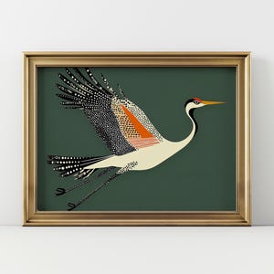 May include: A framed art print featuring a stylized crane in flight. The bird has a white body, black and orange wing patterns, and a long yellow beak. The background is a deep green, and the frame is gold.