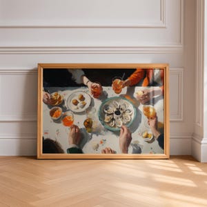 May include: A framed print of a dining scene with a table set for a meal. The table is covered with a floral tablecloth and features plates of food, drinks, and a platter of oysters. People are gathered around the table.