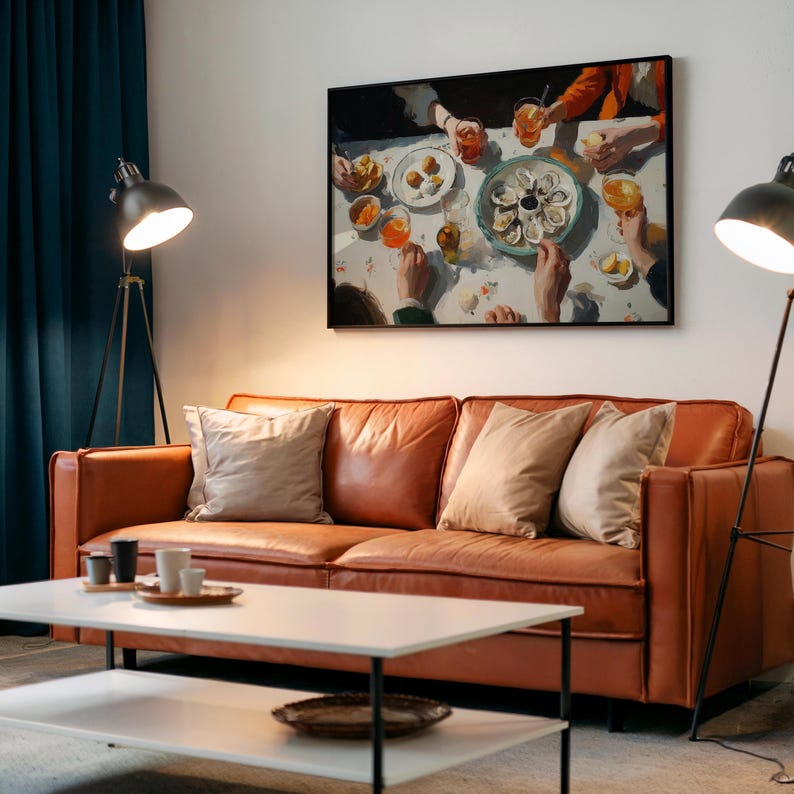 May include: A living room scene featuring a brown leather sofa with beige pillows, a white coffee table, and a black framed painting depicting a dining scene. Two black lamps flank the sofa, and a teal curtain is visible.