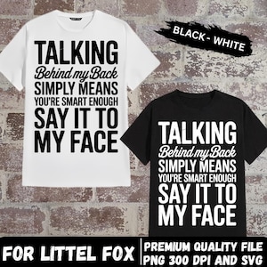 Puede incluir: Dos camisetas, una blanca y otra negra, cada una con el texto "TALKING Behind my Back SIMPLY MEANS YOU'RE SMART ENOUGH SAY IT TO MY FACE" en negrita, en blanco y negro. Las palabras "BLACK - WHITE" están escritas en una pancarta negra.