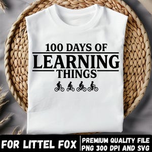 May include: White t-shirt with the text "100 DAYS OF LEARNING THINGS" in black. Below the text are four small black silhouettes of people riding bicycles. The shirt is displayed on a woven basket.