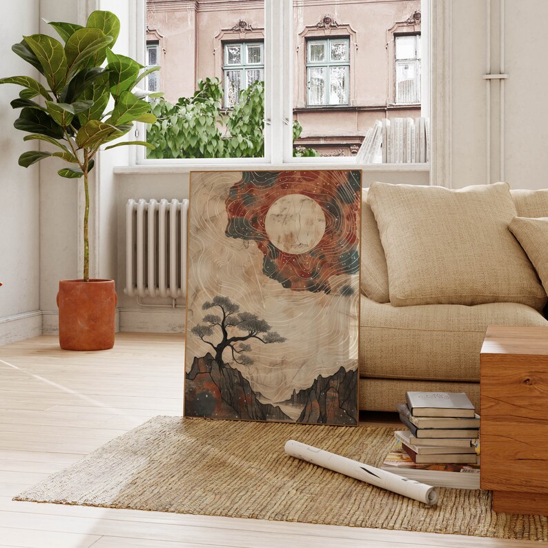 May include: A framed print of a watercolor painting depicting a stylized landscape with a large, full moon, a small pine tree, and mountains. The painting has a muted color palette of browns, blues, and grays.
