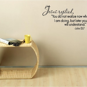 May include: A wicker end table with a book and a yellow mug on top. The wall behind the table has a black and white quote from the Bible: "Jesus replied, "You do not realize now what I am doing, but later you will understand." -John 13:7"