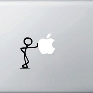 Op de afbeelding: Een zilveren laptop met een zwart stokfiguur dat een witte Apple-logo sticker duwt.
