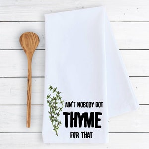May include: White kitchen towel with a green thyme sprig and black text that reads "Ain't nobody got thyme for that."