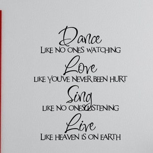May include: Black and white text on a white wall that reads "Dance like no ones watching, Love like you've never been hurt, Sing like no ones listening, Live like heaven is on earth."