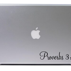 May include: A silver laptop with an Apple logo and a black vinyl sticker that says "Proverbs 3:5".