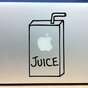 May include: A silver laptop with a black and white drawing of a juice box with an apple and the word "JUICE" on it.
