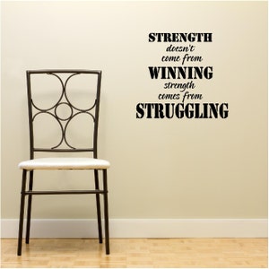 May include: A black and white inspirational quote on a beige wall. The quote reads "Strength doesn't come from winning, strength comes from struggling."
