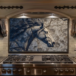 May include: A large, framed artwork featuring a detailed relief of a horse's head. The horse is depicted in shades of gray and white, with a textured, cracked background. The artwork is mounted above a stainless steel gas range.