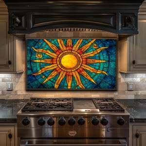 May include: A stained glass-style kitchen backsplash featuring a vibrant sun design. The artwork showcases a bright yellow sun center with radiating orange and yellow rays against a teal and blue background. The backsplash is installed above a stainless steel gas range.