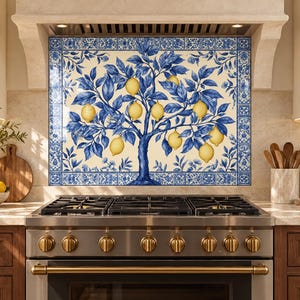 Lemon tree glass splashback behind an induction cooktop in a modern kitchen with light oak cabinets and pale stone counters.