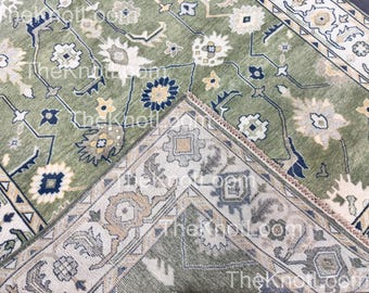 Könnte beinhalten: Nahaufnahme eines grün-beigen gemusterten Teppichs. Der Teppich zeigt florale und geometrische Designs in Grün-, Beige- und Marineblautönen. Der Rand des Teppichs hat ein detailliertes Muster. Der Text "Theknot.com" ist sichtbar.