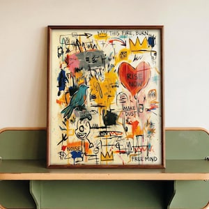 May include: Abstract art print in a wooden frame. The artwork features a blue bird, a red heart with the words "RISE NOW", and various scribbled text and symbols in vibrant colors. The words "THIS FIRE, BURN", "MAKE DUST", "NOISE", and "FREE MIND" are also visible.