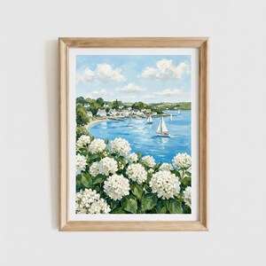 May include: A framed painting depicting a coastal scene with white hydrangea flowers in the foreground. The background features a blue bay with several sailboats, a small village with white houses along the shoreline, and a light blue sky with clouds.