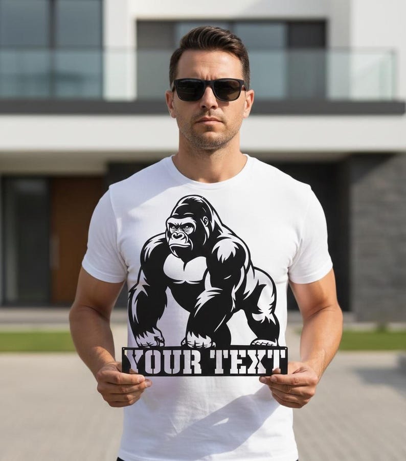 A man wearing a white t-shirt with a graphic of a gorilla and holding a sign that says "YOUR TEXT".