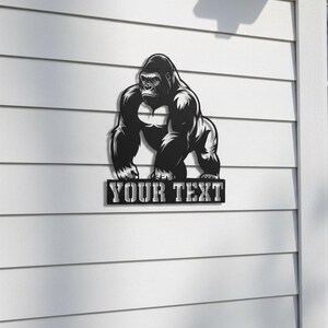 A black and white illustration of a gorilla is mounted on a white wall, with the text "YOUR TEXT" below it.
