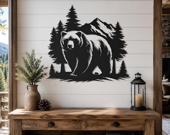 May include: A black metal wall art piece featuring a silhouette of a large bear standing in front of a dense forest of pine trees with a mountain range in the background. The design is flat, monochromatic, and depicts a natural wilderness scene.
