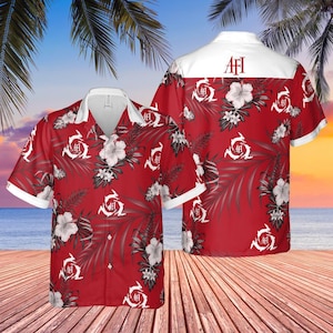 May include: Red Hawaiian shirt with white floral and leaf pattern. The shirt has a white collar and cuffs, and the letters "AFI" are printed on the back. The shirt is displayed on a wooden deck with a beach and palm trees in the background.