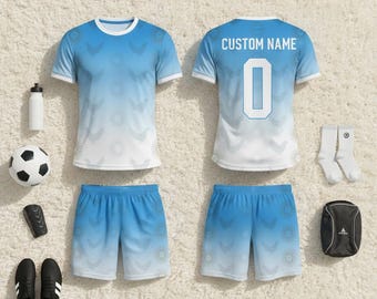May include: A complete soccer uniform set in shades of blue and white, including a jersey, shorts, socks, and a sports bag. The jersey features a gradient design and the text "CUSTOM NAME" and the number "0" on the back. Accessories include a soccer ball, water bottle, and cleats.