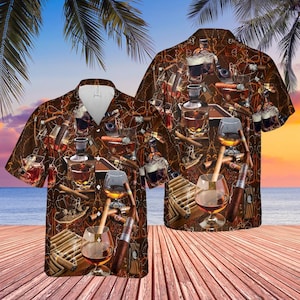 May include: Brown button-up shirt with a tropical theme, featuring a pattern of cigars, whiskey glasses, decanters, and bottles. The shirt has a white collar and is set against a beach scene with palm trees and a sunset.