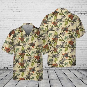 Puede incluir: Una taza de cerámica blanca con un asa negra y el texto "But First, Coffee" en negrita negra. La taza se encuentra sobre un fondo borroso, sugiriendo un ambiente acogedor.