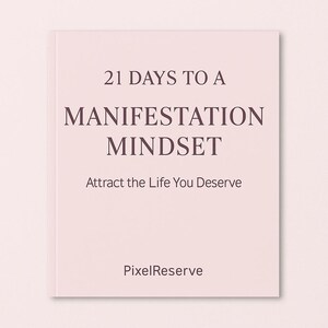Peut inclure: Livre rose avec le titre "21 Days to a Manifestation Mindset" en texte marron foncé. La couverture indique également "Attract the Life You Deserve" et présente le logo PixelReserve. Le livre est fermé et posé sur un fond rose.