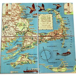 May include: A vintage map of Cape Cod, Martha's Vineyard, and Nantucket, divided into four tiles. The map is printed on a blue background with brown, green, and yellow lines and text. The map includes a compass rose and a whale illustration.
