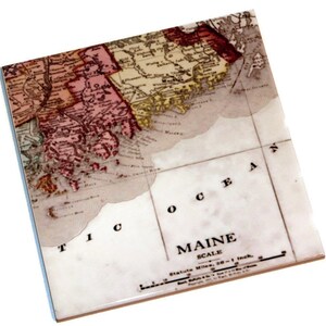 May include: A vintage map of Maine with a white background and red, yellow, and brown markings. The map shows the coastline of Maine and the Atlantic Ocean. The text "MAINE" and "SCALE" are printed on the map. The scale is 20 miles to 1 inch.