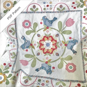 Puede incluir: Un edredón hecho a mano con un diseño floral central y detalles de pájaros azules. El edredón presenta un fondo blanco con rayas verticales, rodeado de aplicaciones florales y de pájaros en rojo, azul y verde. El texto "PDF Pattern" es visible.