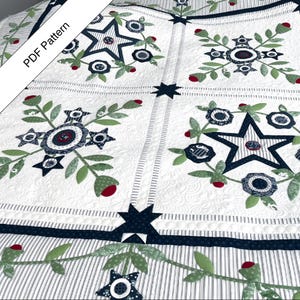 Puede incluir: Colcha blanca con un patrón repetido de estrellas azul marino, detalles florales y bayas rojas. La colcha presenta un borde a rayas y el texto "PDF Pattern" en la esquina superior izquierda. El diseño es una mezcla de elementos geométricos y florales.