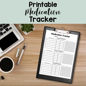 May include: A black clipboard holds a white "Medication Tracker" sheet with sections for morning, afternoon, and evening medications. The image includes a laptop, pen, coffee cup, and a small plant on a wooden surface.