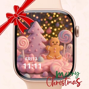 Puede incluir: Una pantalla de reloj inteligente muestra una escena navideña festiva con un hombre de jengibre, un árbol de Navidad rosa y piruletas. La pantalla muestra la hora 11:11 y la fecha Vie 13. Un lazo rojo está en la parte superior izquierda y las palabras "Merry Christmas" están escritas abajo.